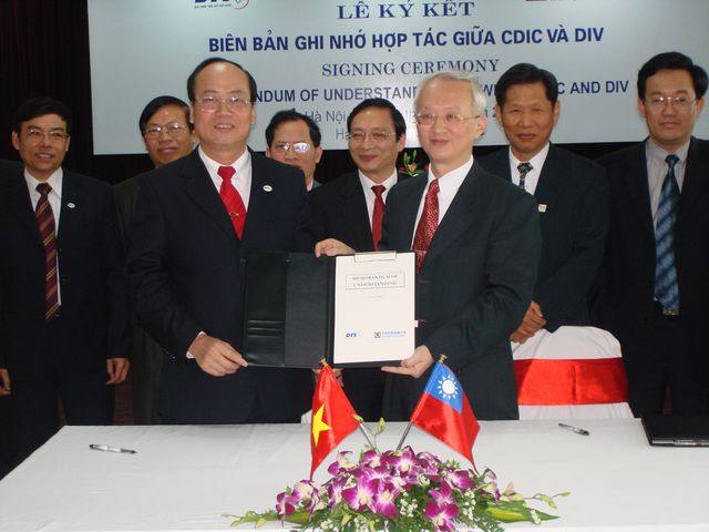Mr. Do Khac Hai （left）, DIV Chairman, and Dr. Ray-Beam Dawn （right）, CDIC’s Chairman, signed the MOU to enhance the mutual cooperation between the two organizations on 15 December, 2006 in Hanoi, Vietnam, with Mr. Huang Nan-Huei, Representative of Taipei Economic and Cultural Office in Vietnam. 