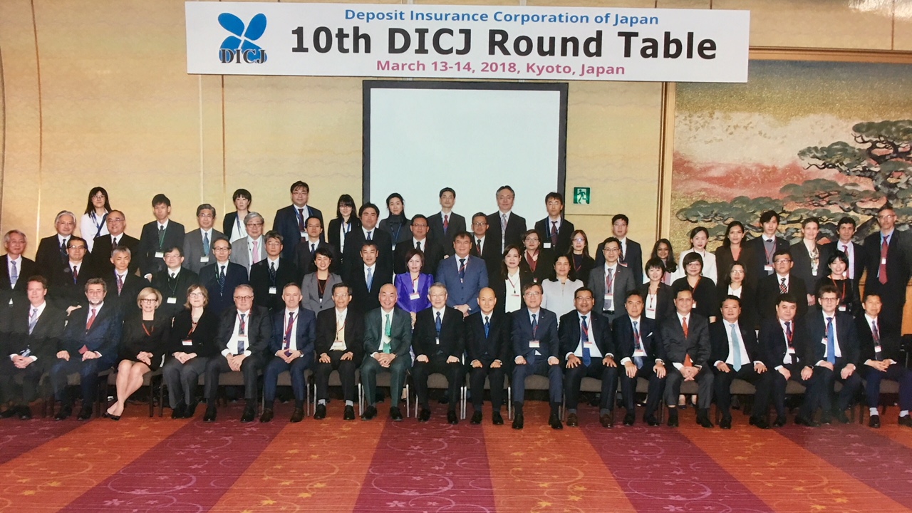中央存款保險公司副總經理蘇財源（前排左7）於107年3月中旬赴日本京都參加日本存款保險公司（DICJ）舉辦之第10屆圓桌會議，與DICJ理事長Mr. Katsunori Mikuniya（正中）、副理事長Takamasa Hisada （前排右9）及全體與會代表合影
